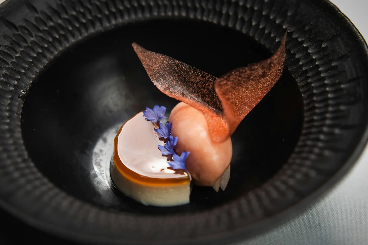 A plated dessert with sorbet and edible flowers